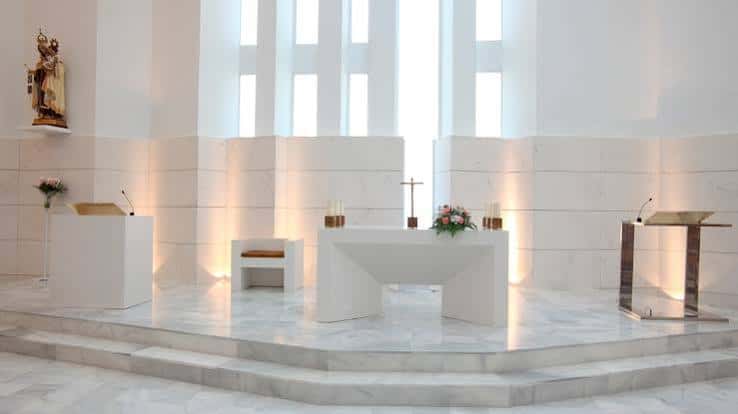 Interior de la Iglesia de las Losas con altar moderno y detalles en mármol blanco
