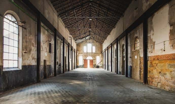 Interior espacioso de la antigua fábrica con techos altos y ventanas arqueadas