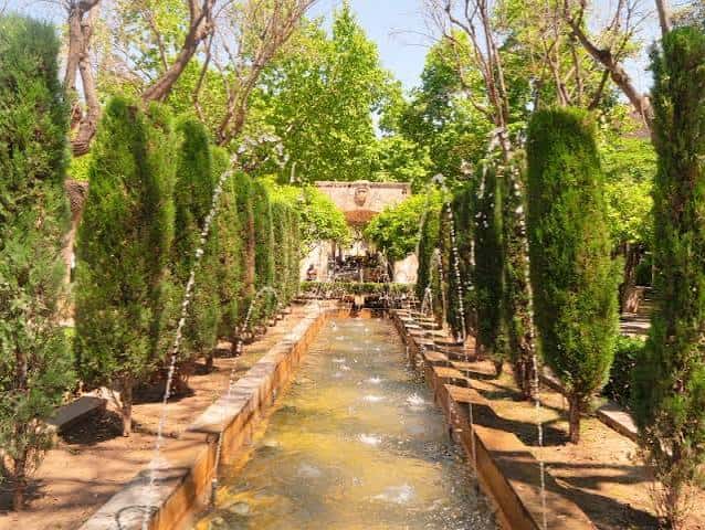 Jardín formal con fuente larga y cipreses