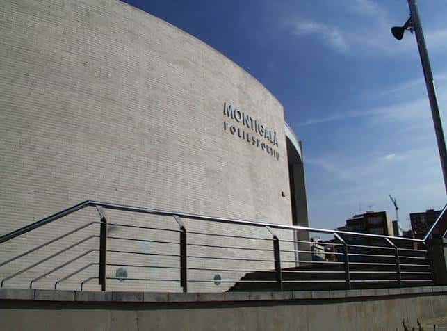 Vista exterior del Polideportivo Montigalà mostrando su fachada curva y el nombre del recinto