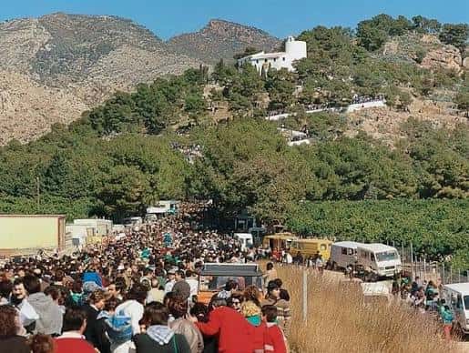 Vista panorámica del monte con la ermita y multitud de visitantes subiendo por las escaleras