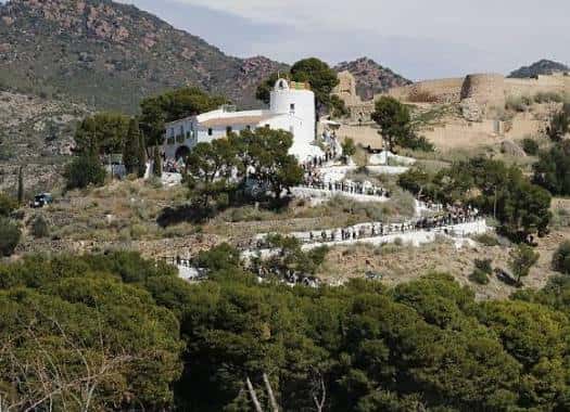 Ermita de la Magdalena desde una perspectiva elevada con senderos y personas caminando