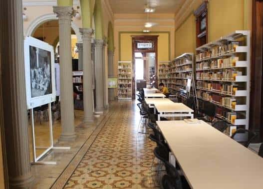 Interior de la biblioteca con columnas clásicas y estanterías llenas de libros