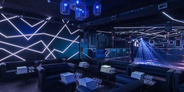 Interior del Posh Club con iluminación LED azul y sofás para eventos