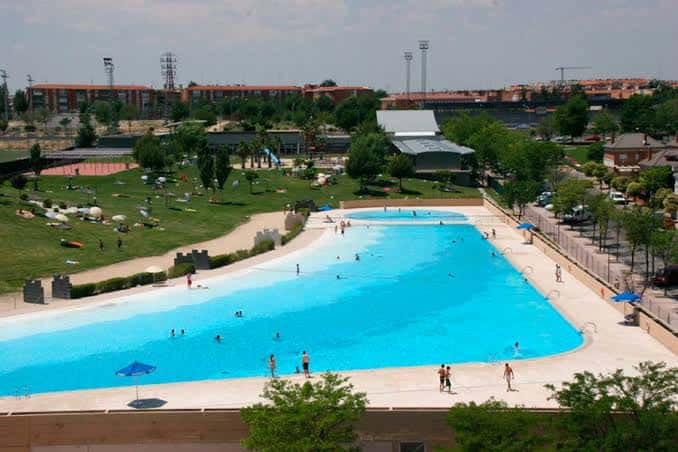 Piscina de Parla rodeada de áreas verdes y edificios residenciales al fondo