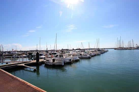 Muelle del puerto con barcos amarrados bajo un cielo soleado