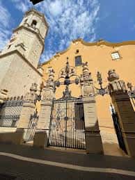 Fachada principal del Convent con torre y portón de hierro forjado