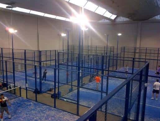 Vista general de las pistas de pádel interiores con jugadores en acción