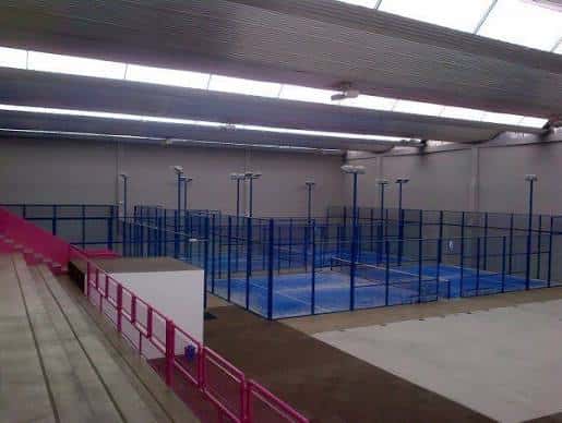 Pistas vacías con gradas y barandillas rosadas en primer plano