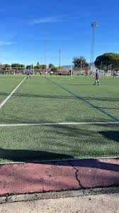 Vista del campo de fútbol con césped artificial bajo un cielo despejado
