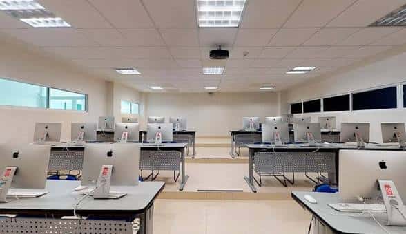 Laboratorio de computación con equipos Apple organizados en filas