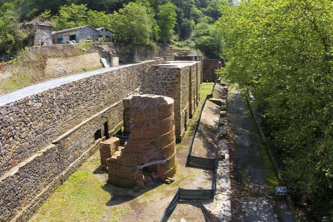 Perspectiva elevada de los hornos de fundición y muros de contención en el paisaje verde de Irún