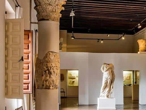 Sala interior con columnas romanas y estatuas clásicas en exposición