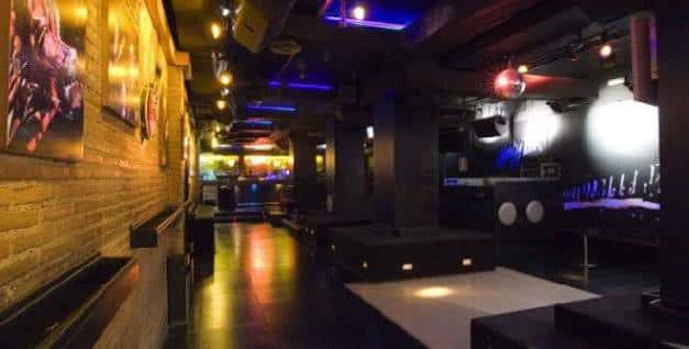 Interior del Honky Tonk con ambiente nocturno y luces de discoteca