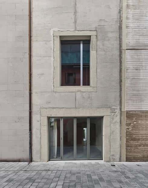 Fachada exterior del edificio con ventana central y puerta de cristal en la planta baja