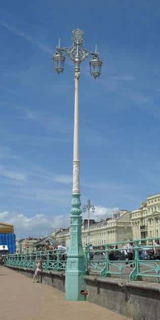 Vista de un farol ornamental en el paseo marítimo de Brighton con edificios históricos al fondo