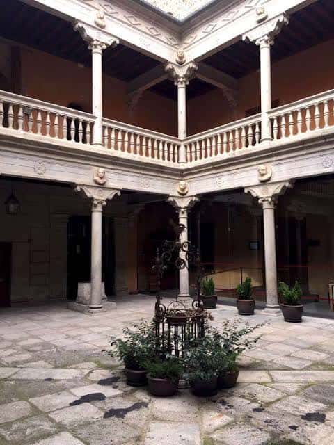 Patio interior renacentista con columnas de piedra y balaustradas decoradas