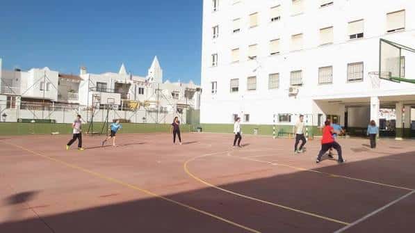 Alumnos jugando al baloncesto en el patio deportivo del instituto