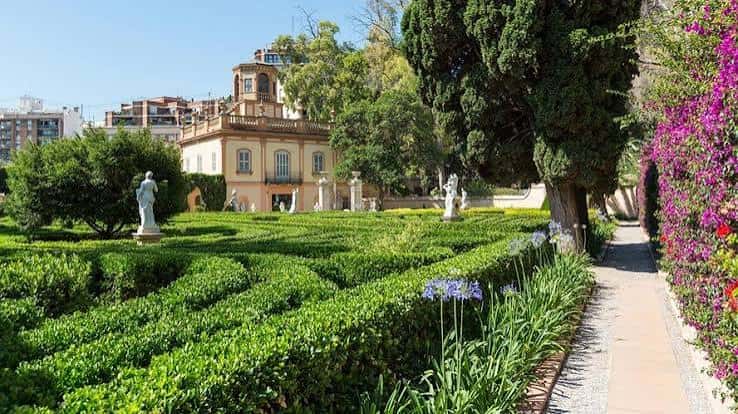 Vista general del jardín con setos geométricos y palacete al fondo