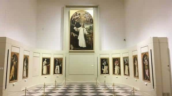 Sala de exposiciones con pinturas barrocas y suelo a cuadros