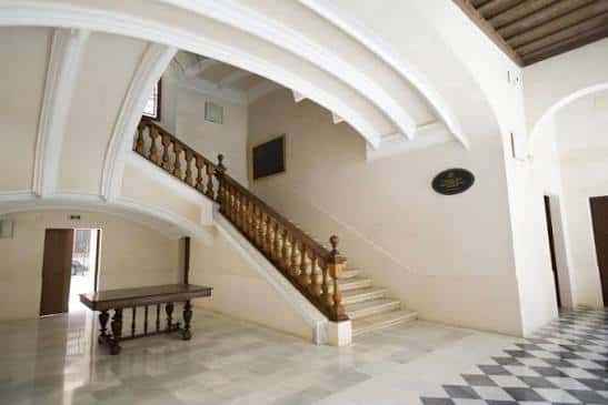 Escalera de mármol con barandilla de madera en el interior del centro