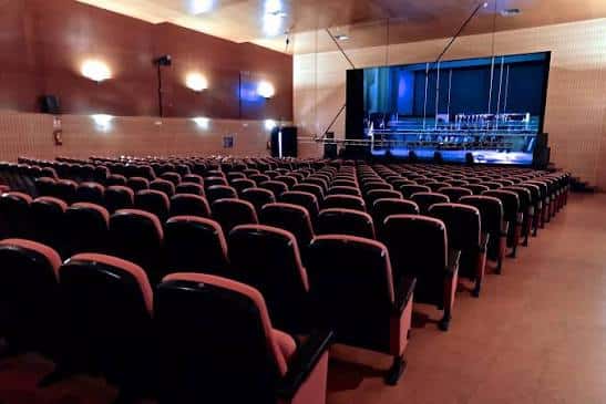 Interior del auditorio con butacas dispuestas frente al escenario iluminado