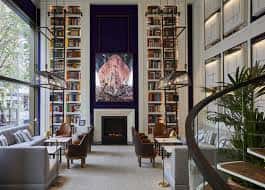 Salón interior con estanterías de libros y chimenea decorativa