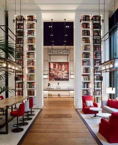 Recepción del hotel con columnas de libros y decoración moderna