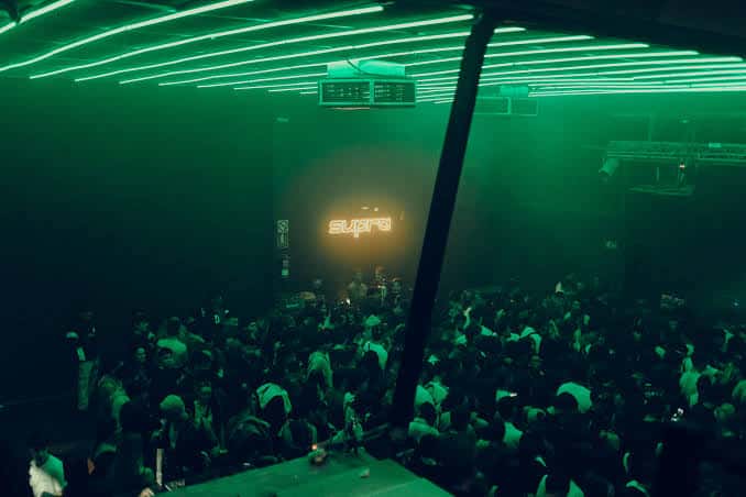 Interior del Supra Music Hall durante un evento con público y luces verdes