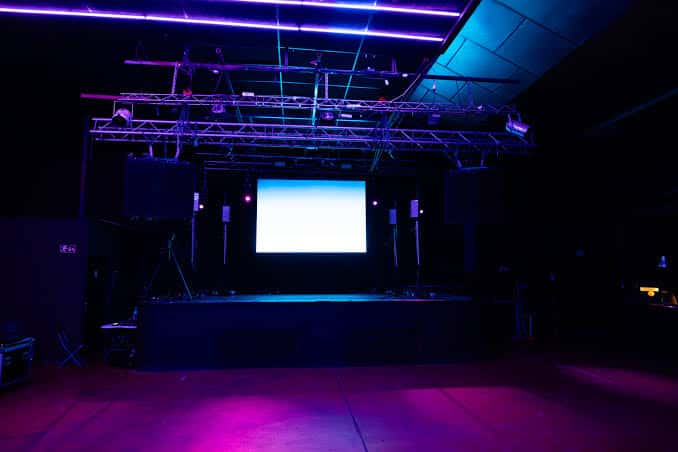 Escenario vacío con sistema de sonido y luces LED en tonos morados