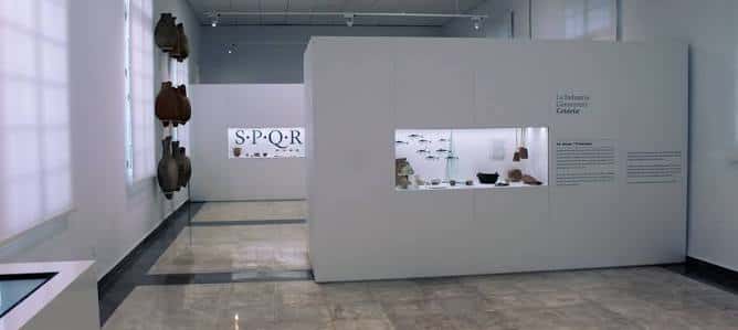 Interior de la sala de exposiciones con artefactos romanos y señalética 'S.P.Q.R'