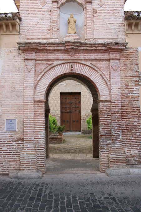 Arco de entrada al patio de los Naranjos con estatua superior