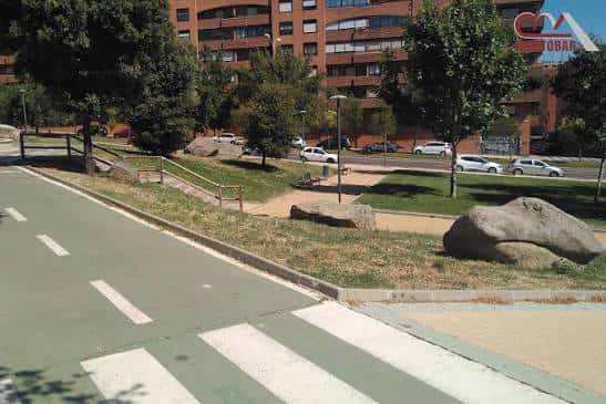 Pista deportiva con sendero peatonal y entorno arbolado