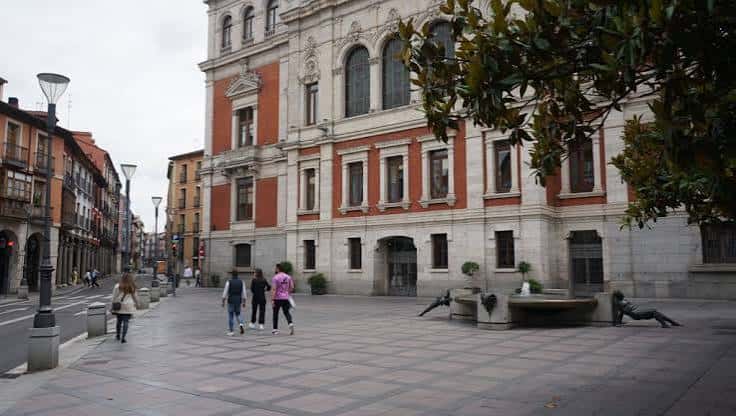 Fachada del edificio principal en la plaza con personas caminando