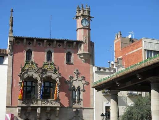 Detalle arquitectónico de la fachada principal con balcones ornamentados y banderas colgadas