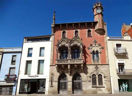 Vista frontal completa del Ajuntament de Granollers con fachada modernista y torre del reloj bajo cielo azul