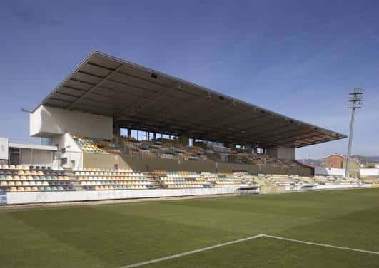 Detalle de la grada principal con techo moderno y asientos multicolores en el Estadi Municipal de Reus