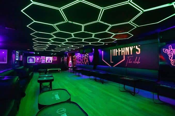 Vista interior del local Tiffany's The Club con luces verdes y decoración moderna