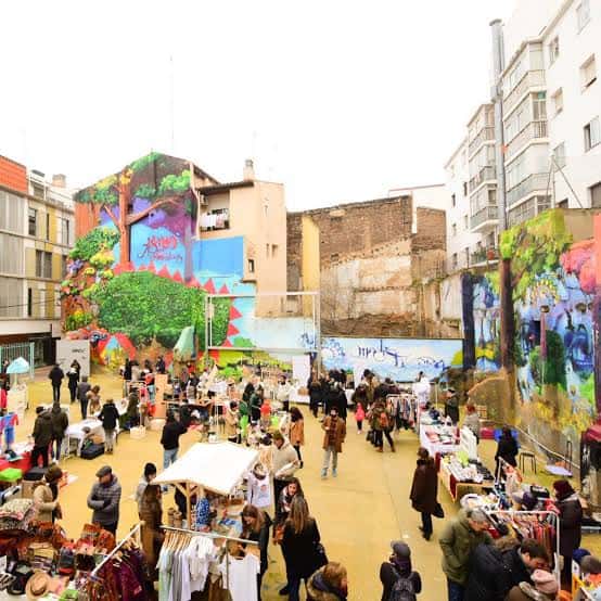 Ambiente festivo del mercado con grafitis coloridos y gente comprando