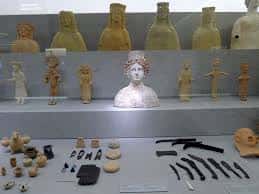 Exposición de artefactos arqueológicos y busto central del museo