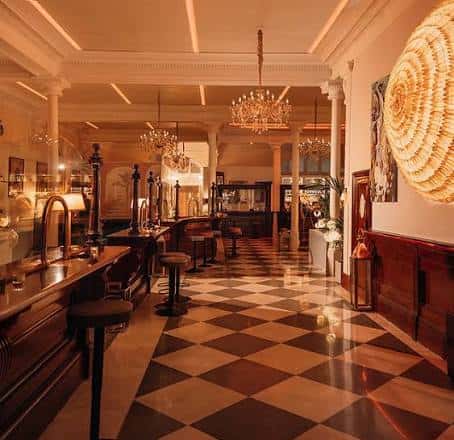 Interior elegante del bar con suelo de damero y lámparas colgantes