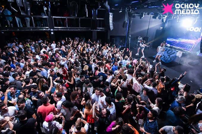 Escenario con artistas en vivo frente a una audiencia entusiasta en el club