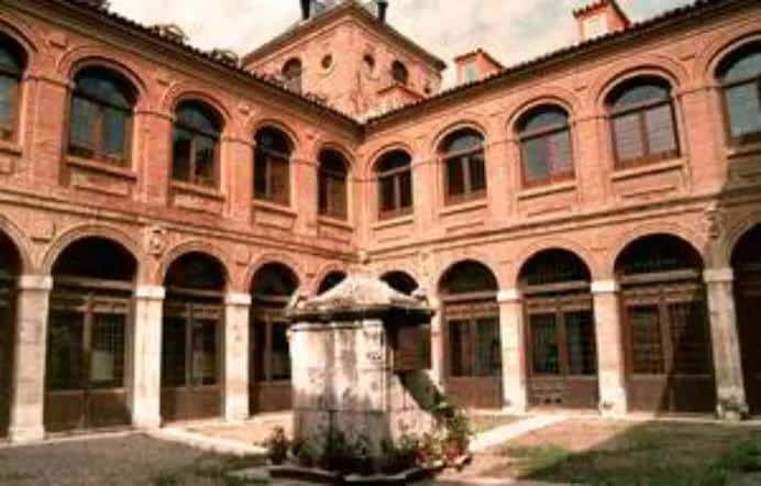 Patio interior del colegio con arcos y fuente central