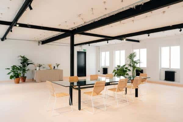 Sala principal del Espacio Larra con mesa larga y plantas decorativas