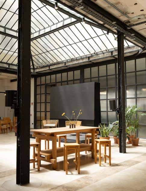 Área interior del espacio con mobiliario de madera y estructura industrial