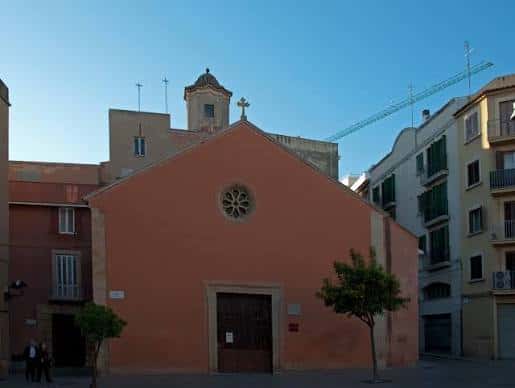 Vista exterior de la fachada principal de la Iglesia de Sant Llorenç con su característica pared naranja y rosetón