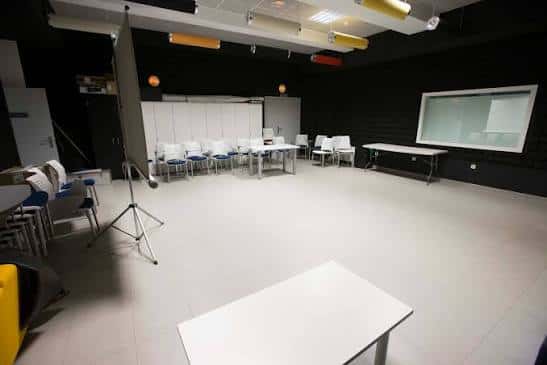 Sala polivalente de Espacio Joven con mobiliario modular y escenario