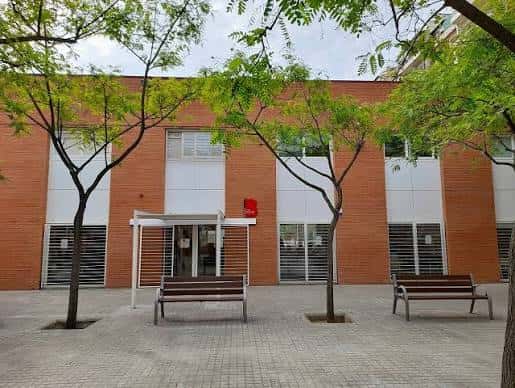 Fachada exterior del Casal de Gent Gran Parc del Clot con jardines y bancos