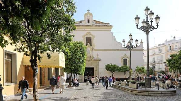 Vista exterior de la Iglesia de San Francisco en Cádiz con plaza y árboles