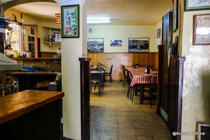Interior acogedor de la bodega con mesas cubiertas de cuadros rojos y blancos